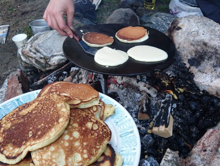 Svelesteking på båltakke. Et fat med ferdige sveler i forgrunnen.